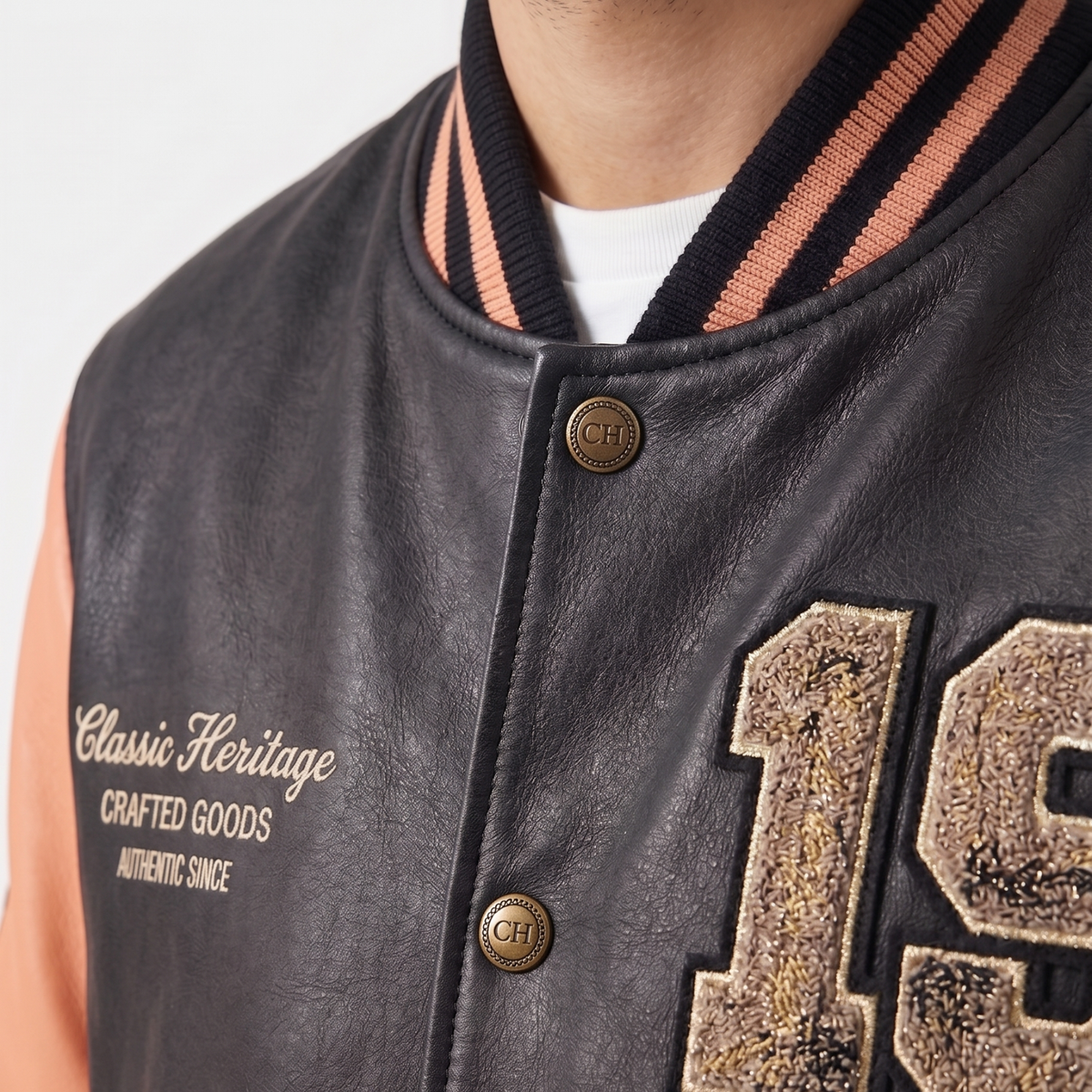 Close-up of a black leather jacket with 'Classic Heritage' branding and '19' embroidery.