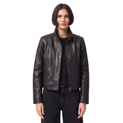 Woman wearing black leather moto jacket with snap buttons and zipper, styled with dark jeans