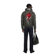 Gray leather jacket with red flame skull design, worn with navy pants and black bag