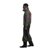 Man wearing olive green leather bomber jacket with red graphic patch, carrying black leather shoulder bag
