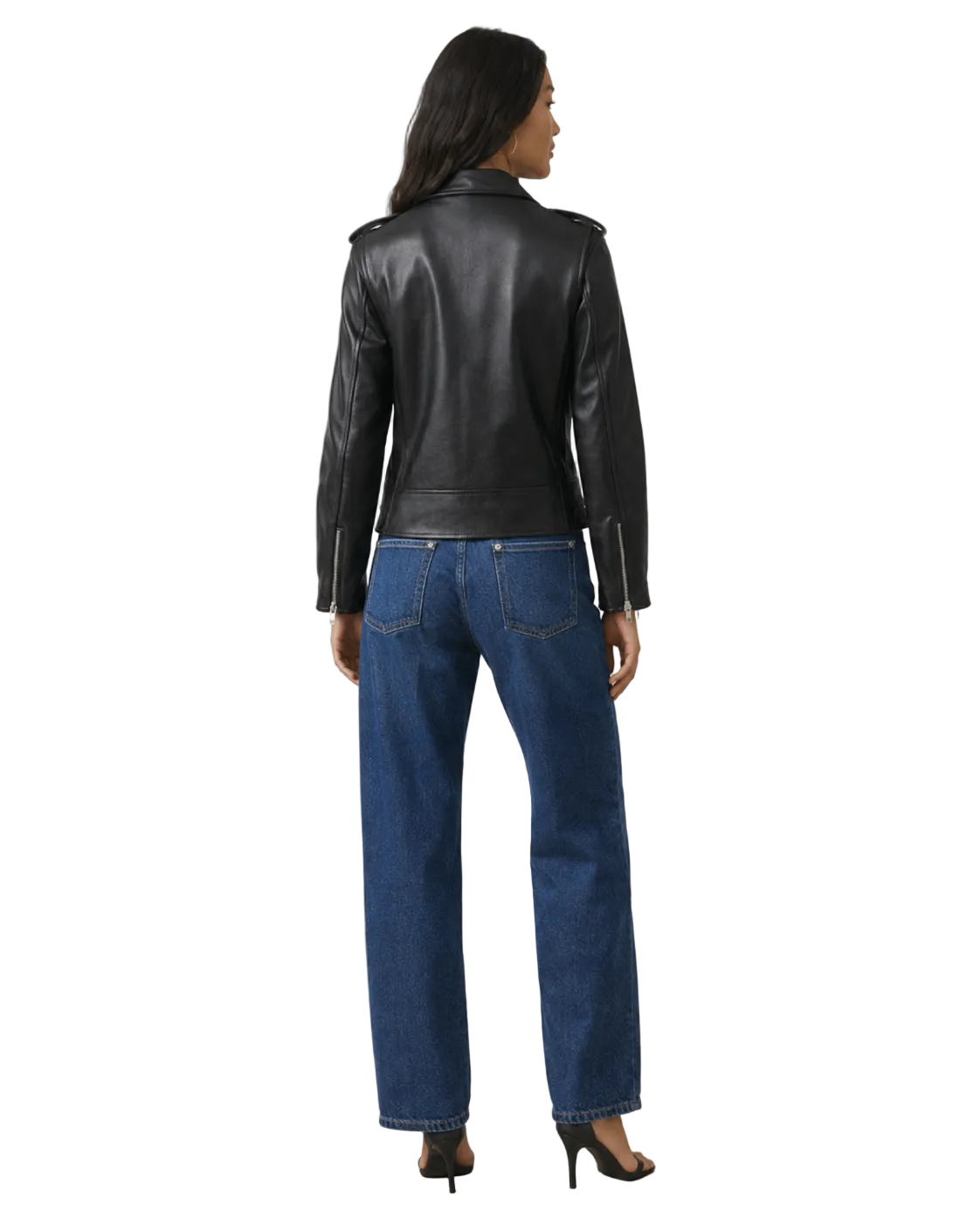 Woman wearing black leather moto jacket with zipper details, paired with wide-leg blue jeans and heels