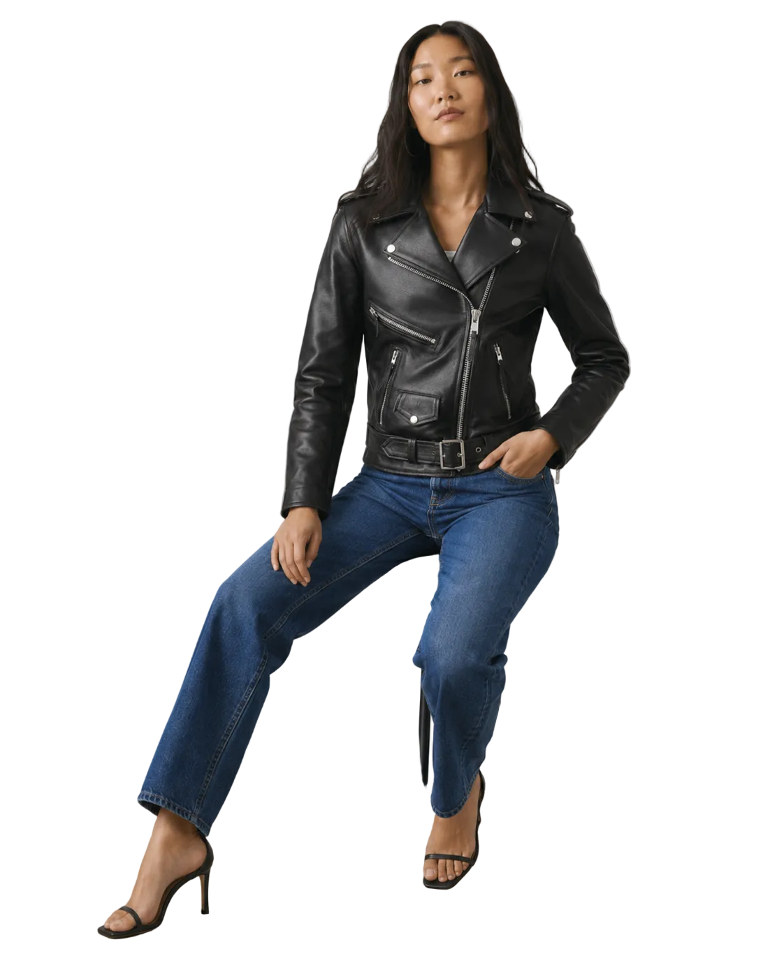 Woman in black leather moto jacket, blue jeans, and heels, posing confidently