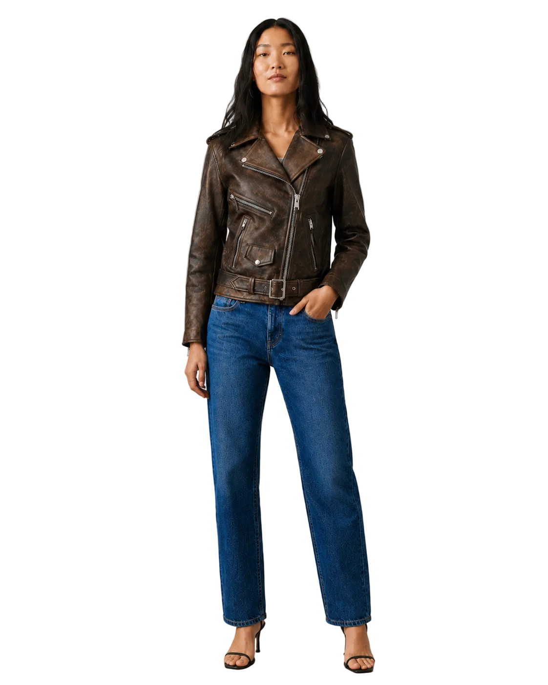 Woman in brown leather moto jacket with belt, paired with blue wide-leg jeans and heels