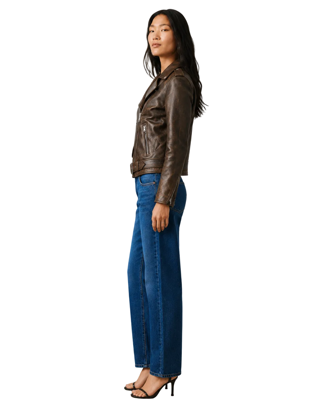 Woman in brown leather moto jacket, blue wide-leg jeans, and black heels, side view