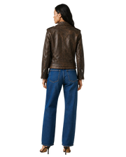 Woman wearing brown leather jacket and blue wide-leg jeans, back view