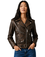 Woman wearing brown distressed leather moto jacket with zippers and belt, paired with blue jeans
