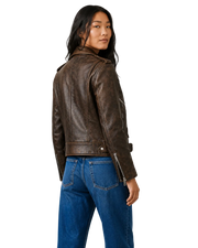 Woman wearing distressed brown leather moto jacket with zippers, paired with blue jeans