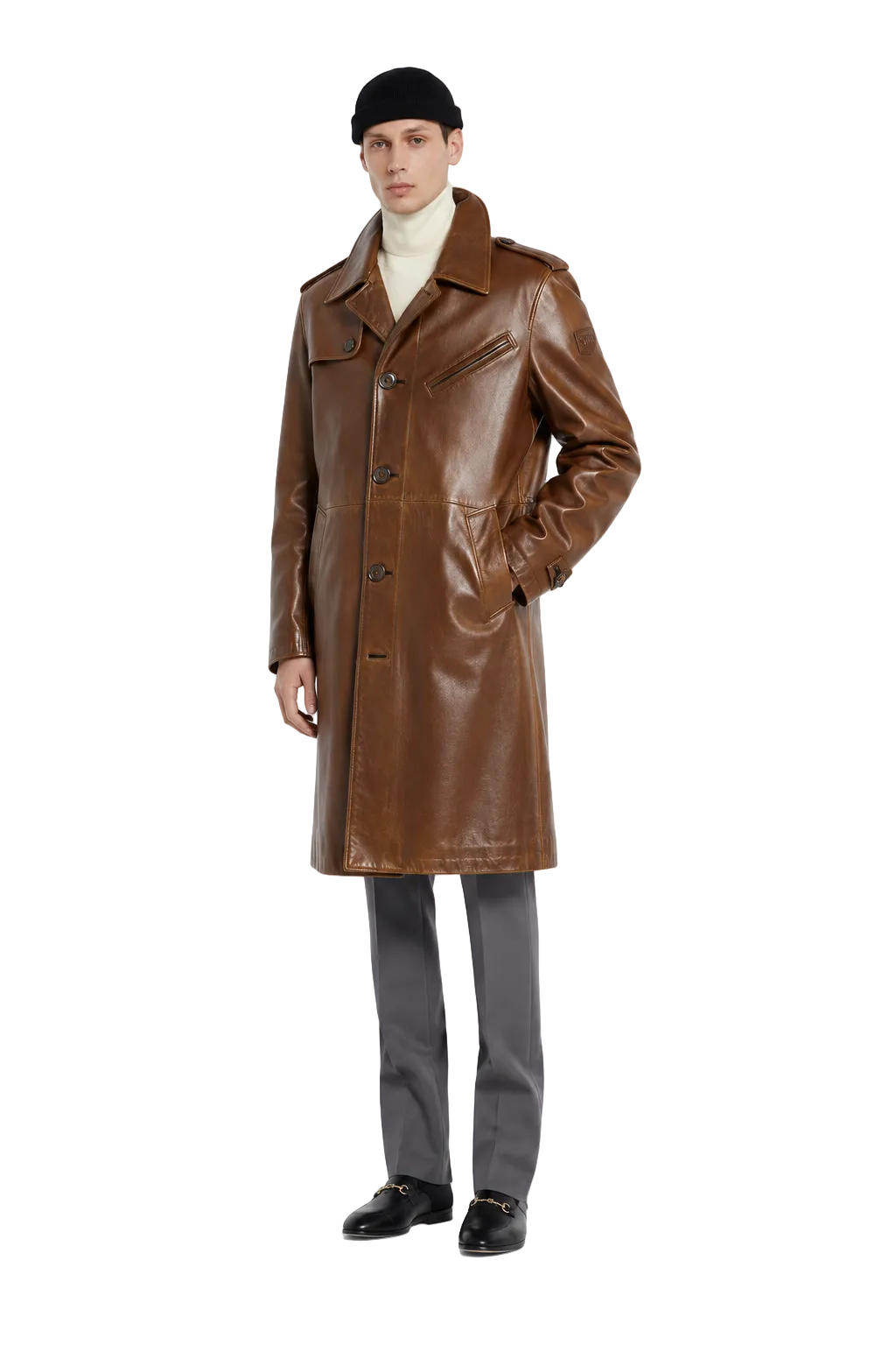 Men's brown leather trench coat with classic collar, front buttons, and pockets, styled with beanie and loafers