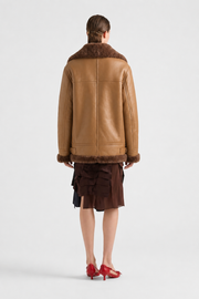 Brown shearling coat with fur collar and cuffs, worn with ruffled skirt and red heels