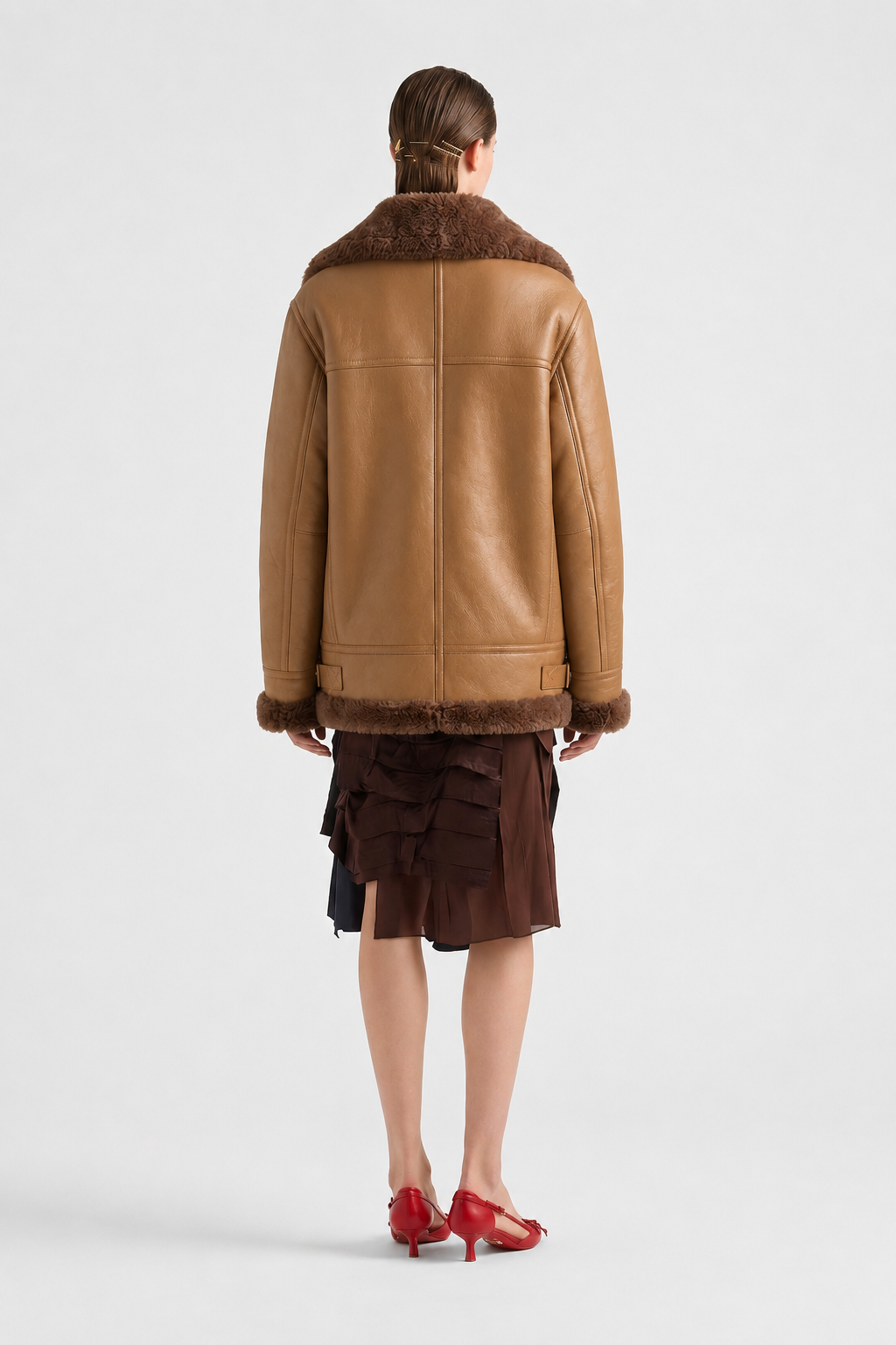 Brown shearling coat with fur collar and cuffs, worn with ruffled skirt and red heels