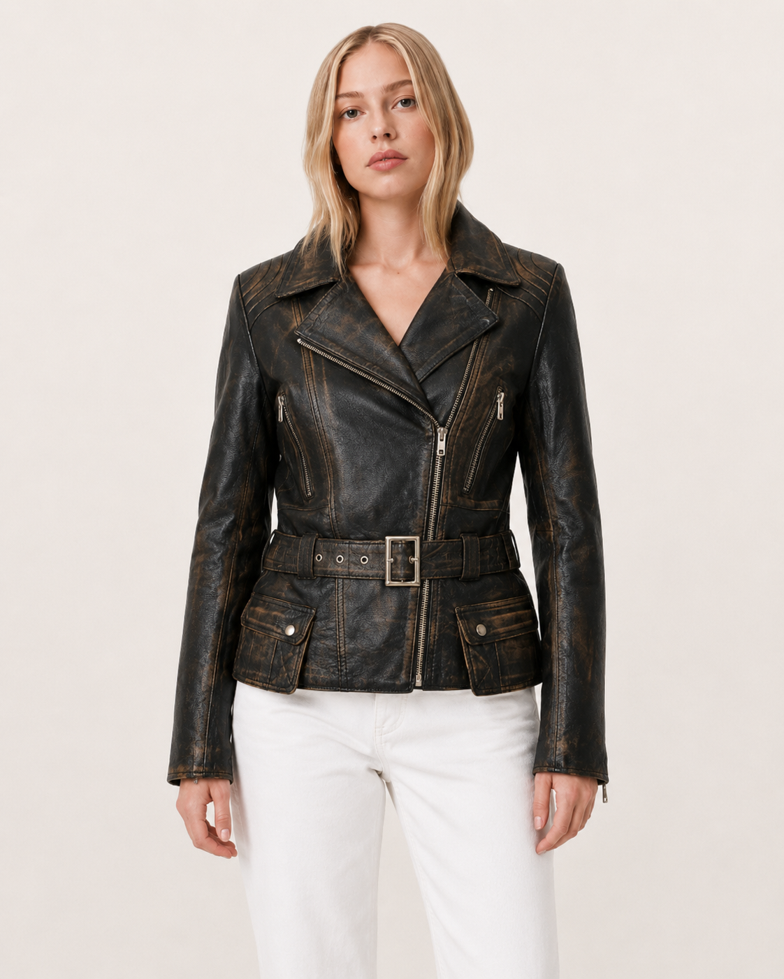 Women's distressed black leather moto jacket with belt and front pockets, paired with white jeans