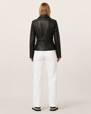 Black distressed leather jacket with belt back view, paired with white wide-leg jeans