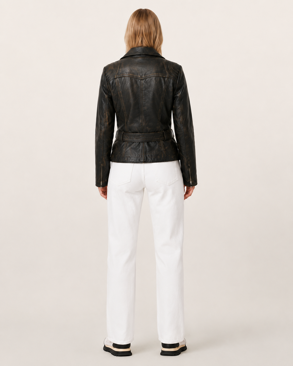 Black distressed leather jacket with belt back view, paired with white wide-leg jeans
