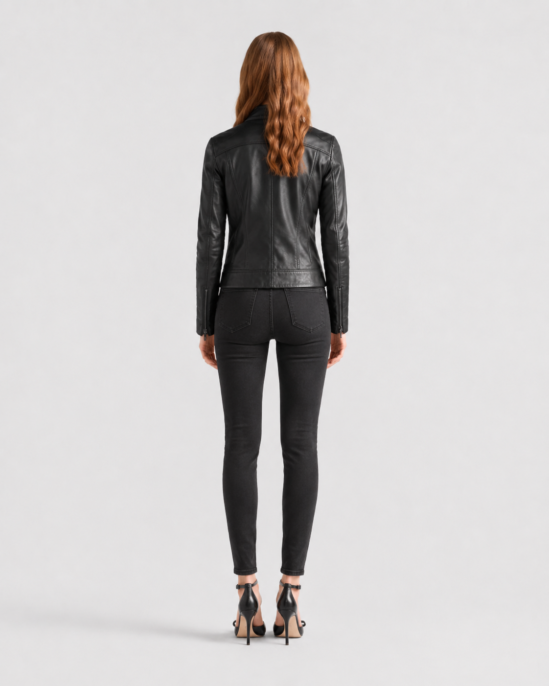 Woman wearing black leather jacket and skinny jeans, back view