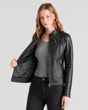 Woman modeling black leather moto jacket with zippers, styled with gray top and black jeans