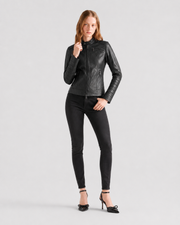 Woman in black leather moto jacket, skinny jeans, and bow heels