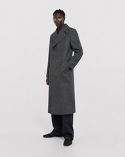 Men's gray double-breasted long coat with patterned wool, styled with dark trousers and loafers