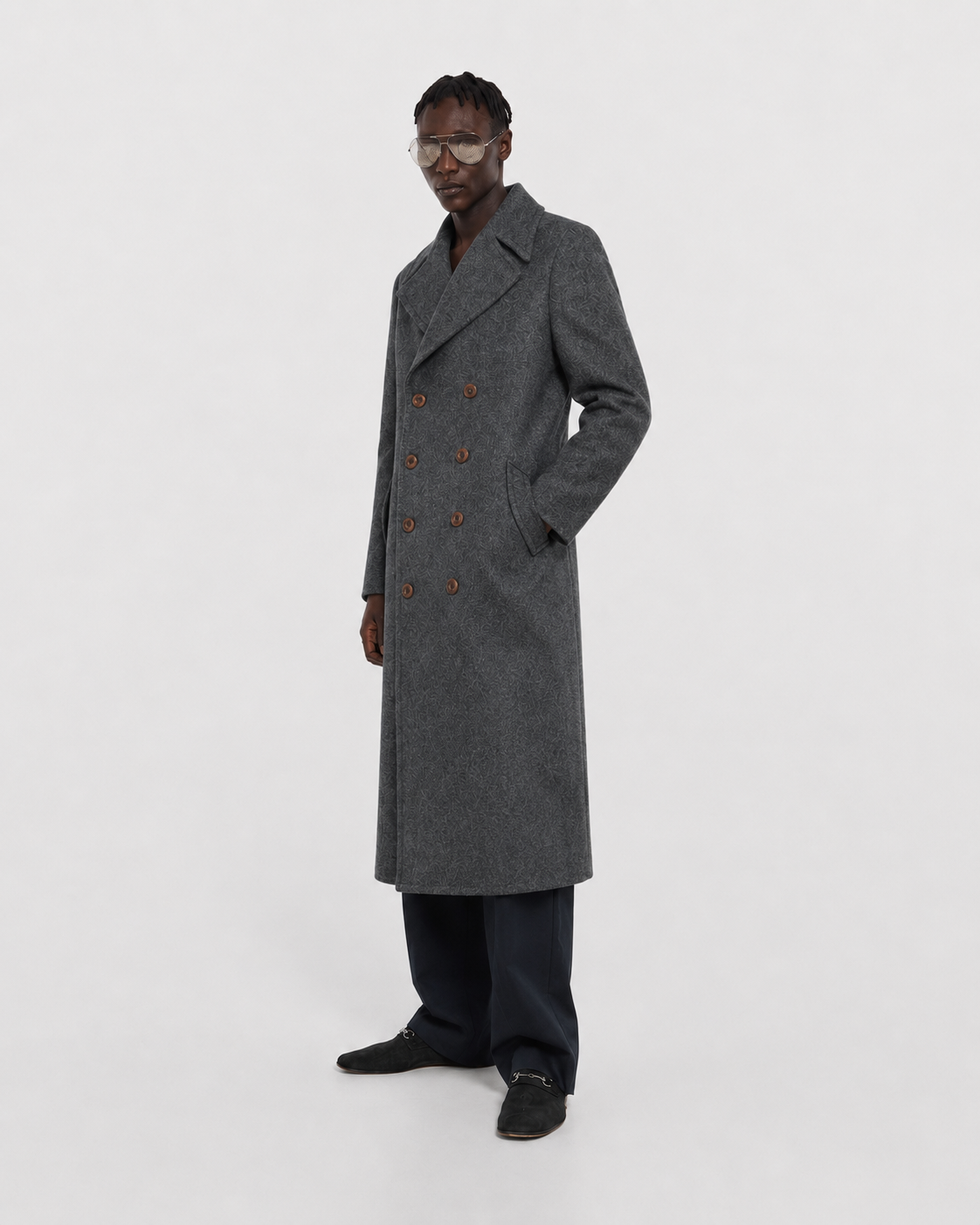 Men's gray double-breasted long coat with patterned wool, styled with dark trousers and loafers
