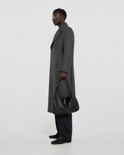 Man in gray patterned wool coat with black leather bag, stylish winter outerwear