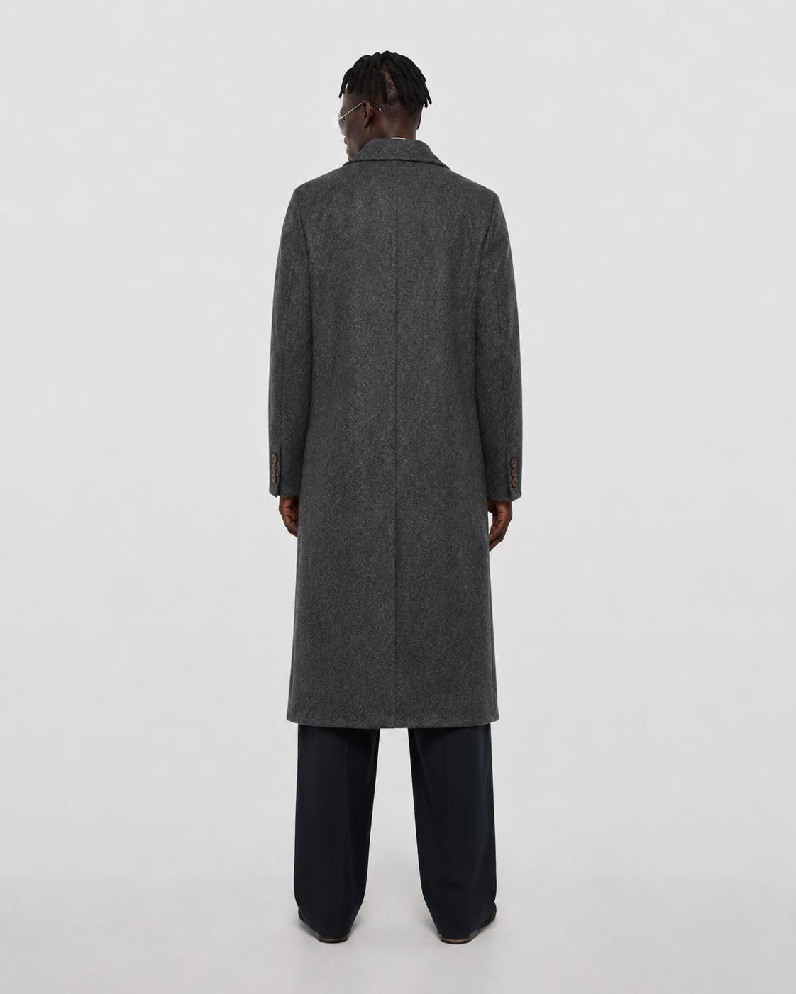 Men's charcoal gray textured overcoat with notched lapel, back view, paired with dark trousers