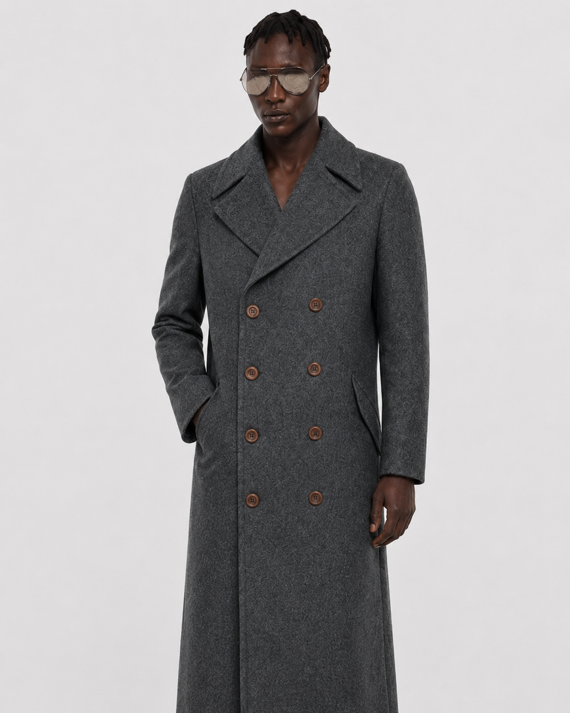Men's charcoal grey double-breasted wool coat with brown buttons, styled with aviator sunglasses