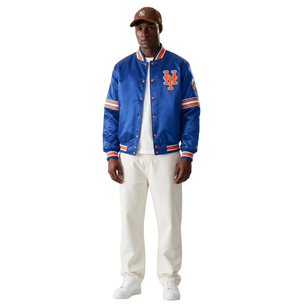 Men's royal blue Mets satin bomber jacket with orange trim and team logo, styled with white pants and cap