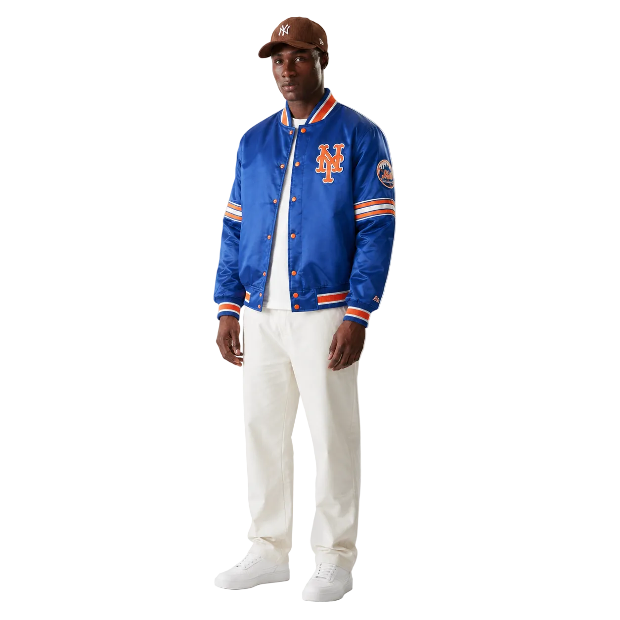 Men's royal blue New York Mets satin varsity jacket with orange trim and team logo, styled with white pants and cap
