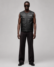Men's black leather vest with Sons of Anarchy patch, paired with dark trousers and sunglasses