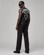 Men's black leather vest with Sons of Anarchy skull graphic, worn with dark trousers and sunglasses
