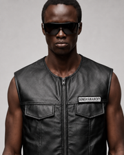 Men's black leather vest with Sons of Anarchy patch, front zipper, and pockets, styled with sunglasses