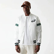 White Philadelphia Eagles varsity jacket with green and black stripes, worn with brown NY cap