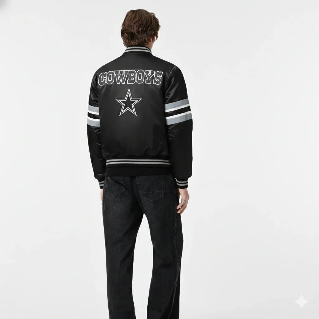 Black Cowboys varsity jacket with star logo, striped sleeves, and back text, worn by model in studio