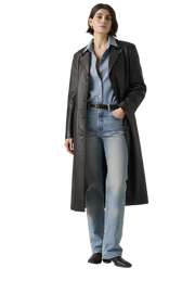 Woman wearing black leather trench coat over denim shirt and jeans