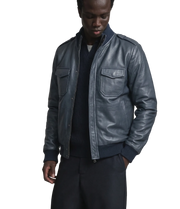 Men's dark gray leather bomber jacket with front pockets and ribbed cuffs, styled over a navy sweater