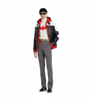 Man wearing Batman graphic turtleneck, black and red hooded jacket, gray trousers, and loafers