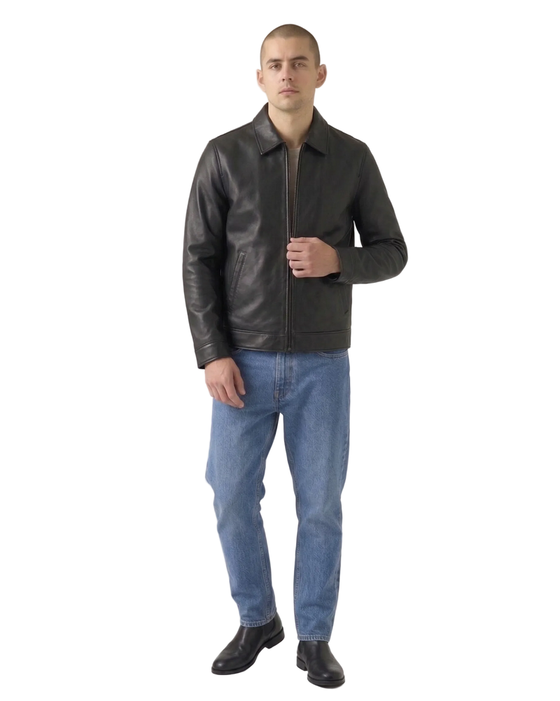 Man wearing a black leather jacket and blue jeans on a white background
