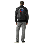 Men's black leather jacket with 'Good for Health' graphic back patch, paired with gray jeans and sneakers
