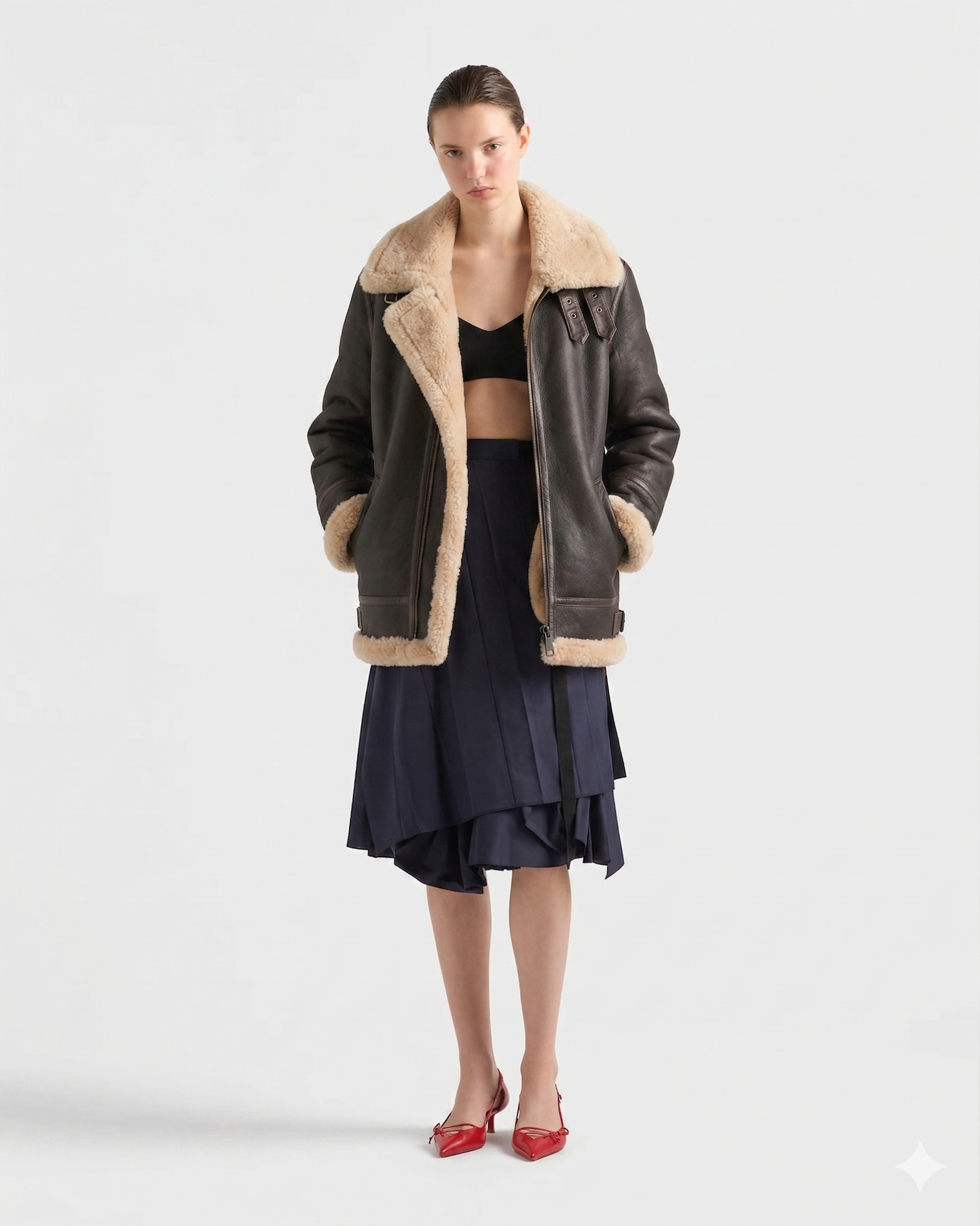 Women's shearling coat with faux fur lining, paired with navy pleated skirt and red heels