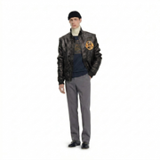Men's black leather bomber jacket with patch, styled with turtleneck, graphic tee, gray trousers, and loafers