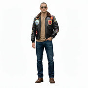 Man wearing black leather bomber jacket with patches, jeans, and aviator sunglasses
