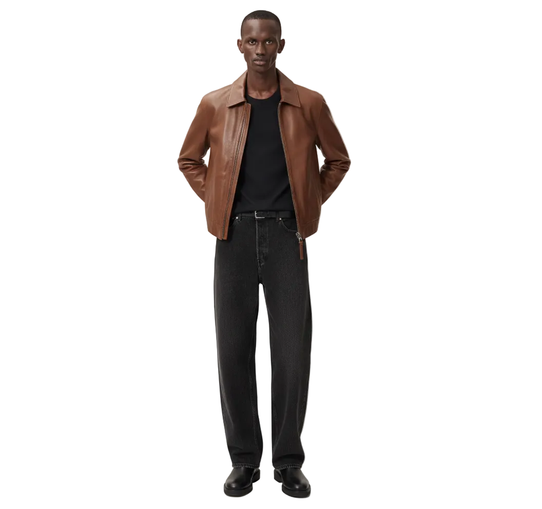 Man wearing a brown leather jacket and black jeans on a white background