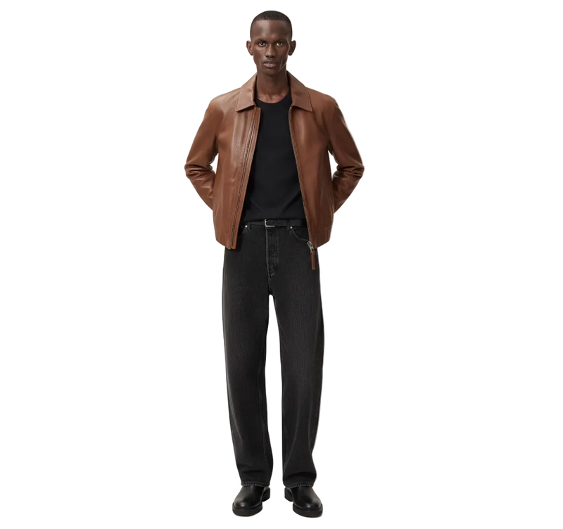 Man wearing a brown leather jacket and black jeans on a white background