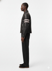 Man in black leather moto jacket with white stripes, paired with dark jeans and casual shoes