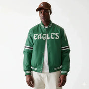 Green Eagles varsity jacket with white lettering, striped sleeves, and button front, worn with cap and white pants