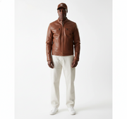 Men's brown leather jacket with zip pockets, styled with white pants and sneakers