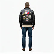 Men's black leather bomber jacket with vintage aviation patches, shearling collar, and classic fit