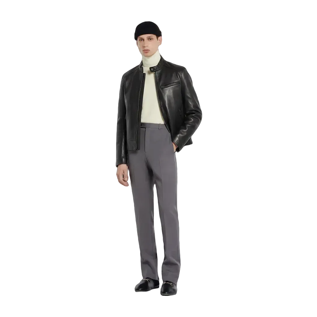 Man wearing a black leather jacket, gray pants, and a black cap on a white background