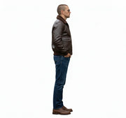 Man in brown leather bomber jacket with shearling collar, blue jeans, and brown shoes, side view