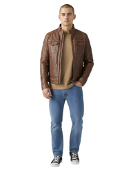 Man wearing brown leather jacket with chest pockets, blue jeans, and black sneakers