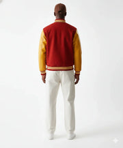 Man wearing red and gold varsity jacket with white pants, back view